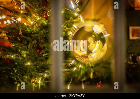 Christmas with a warm, inviting image, looking through a Pub and Restaurant old fashioned circular glass panel, giving an unusual viewpoint Stock Photo