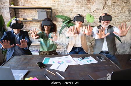 Team of senior manager interacting with business partners in the metaverse - Wearable technology and futuristic concept of job Stock Photo