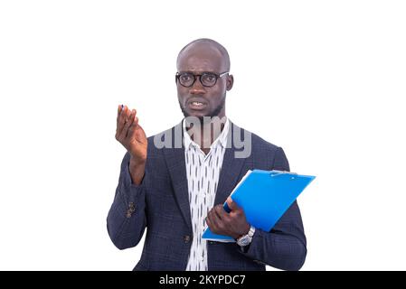 a young man in jacket standing on white background holding a folder and speaking with hand gesture. Stock Photo
