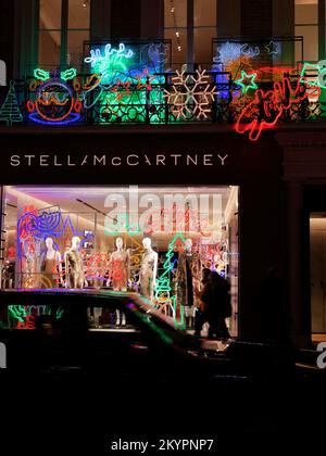 Stella McCartney famous fashion store Christmas Display as a car passes by blurred by motion, Old Bond Street, London. Stock Photo