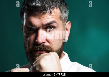 Karate fighter in kimono ready to fight. Combat sport. Martial arts master training in gym. Closeup. Stock Photo