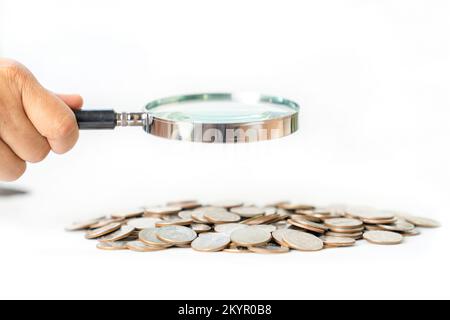 Magnifying Glass With pile of coins isolate on white background