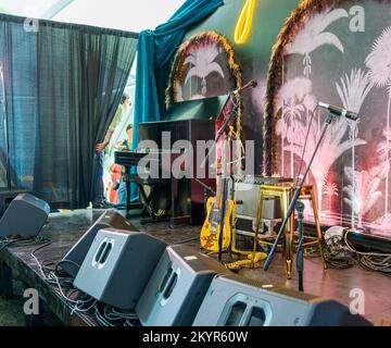 NEW ORLEANS, LA, USA - APRIL 29, 2022: AARP Stage setup as Eric Lindell pulls back the stage curtain preparing to make his entrance at Jazzfest Stock Photo