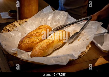 Closeup of short baguettes in a wicker basket at a bakery in Oaxaca City, Mexico Stock Photo