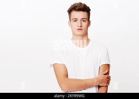 Ready for a day out. Studio portrait of a young man looking at the camera and holding his arm. Stock Photo