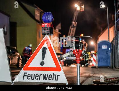 Urbach, Germany. 01st Dec, 2022. A fire department set-up man secures a hydrant. A fire in the family house caused damage of about 400 000 euros. The 56-year-old homeowner had put a pot with hot ashes on the terrace on Thursday evening. According to the report, the pot had ignited and started a fire that spread to the facade, the house entrance and finally the attic. (to dpa: 'Pot with hot ash on balcony: residential building burns down') Credit: Kohls/SDMG/dpa/Alamy Live News Stock Photo