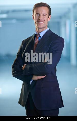 Succeeding in the realm of finance. A young businessman standing and looking confidently at the camera with his arms folded. Stock Photo