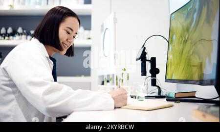 Scientist, planning and asian woman working in lab for research innovation, writing results or science analytics at desk. Laboratory, forensic biology Stock Photo