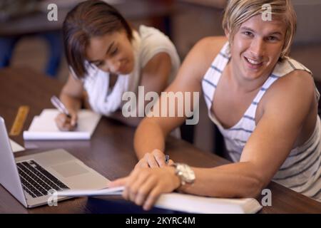 Working towards a bright future. A young man and woman studying for exams in the library. Stock Photo