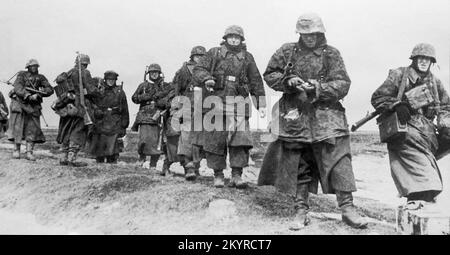 World War Two, Waffen SS Soldiers in Camouflage Smocks advance in the spring of 1944 on the Eastern Front near Tarnopol in the Ukraine Stock Photo