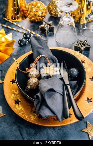 A black tablecloth, expensive utensils and gold details decorate the  wedding table Stock Photo - Alamy