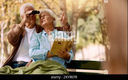 Happy senior couple bird watching in park for relax bonding time together, freedom and retirement peace on outdoor bench. Elderly marriage love Stock Photo