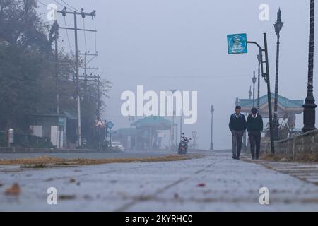 December 2, 2022, Srinagar, Jammu and Kashmir, India: School children walks along he bank of Dal lake during a cold and foggy morning in Srinagar on December 12, 2022. Jammu and Kashmir is witnessing the brunt of climate change and average mean temperature in last 28 years has climbed up by 2.32Â°C and 1.45Â°C. (Credit Image: © Adil Abbas/ZUMA Press Wire) Stock Photo