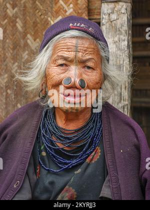 Ziro, Arunachal Pradesh, India - 02 24 2009 : Face portrait of old Apatani tribal woman with traditional facial tattoos and nose plugs Stock Photo