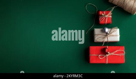 Christmas tree made of gift boxes and decorative star on white background. Top view, flat lay, copy space. Stock Photo