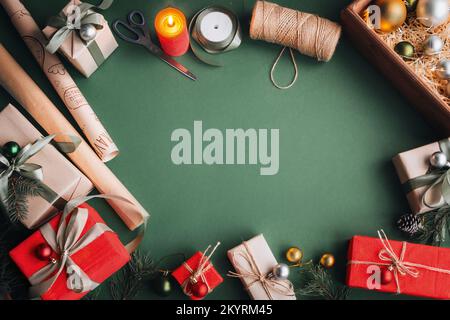 Creative hobby. Things for wrapping Christmas presents. Wrapping paper, scissors, twine tape. Making bow at xmas gift box, decorated on olive table, t Stock Photo