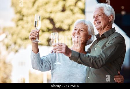 Senior couple, champagne toast and hug with love, relationship happiness and care in home backyard. Elderly man, woman and glass for celebration Stock Photo