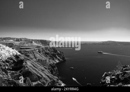 Santorini, Greece - September 16, 2022 : Panoramic view of a ferry boat arriving at the picturesque island of Santorini Greece in black and white Stock Photo