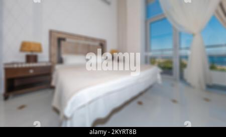 Defocused and blurred photo of luxury and modern bedroom with sea view in hotel apartment interior design. Ideal for background. Stock Photo