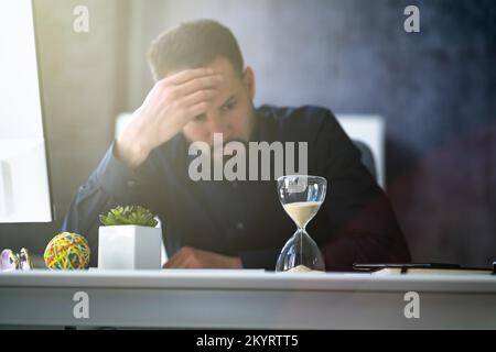 Late Invoice And Billing Deadline With Hourglass At Desk Stock Photo