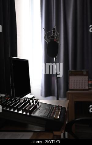 Creative studio interior with professional condenser microphone and blank screen computer. Podcasts and technology concept Stock Photo