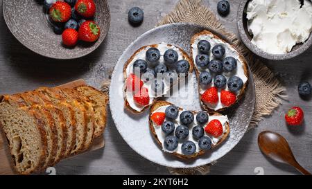 Fresh breakfast with blueberry, strawberry and ricotta rye sandwiches Stock Photo