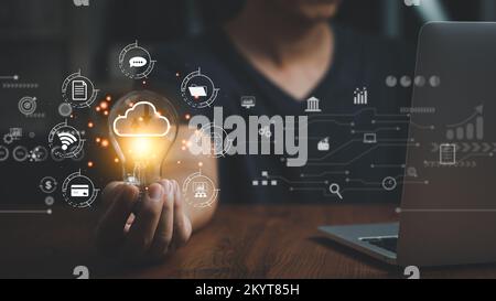 Business internet connection technology and digital marketing financial big data banking.Hand holding light bulb and laptop computer on desk. Stock Photo