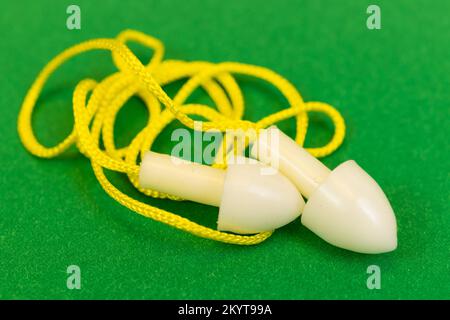 Silicone reusable ear plugs for human ears on green background Stock Photo