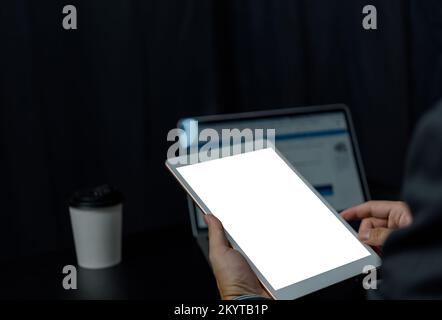 Close up hand man holding tablet blank white screen mock up on desk. Stock Photo