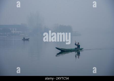 Srinagar, India. 02nd Dec, 2022. A Kashmiri boy rows his boat on Dal Lake to reach school during a cold morning in Srinagar. Night temperatures across Kashmir dropped below the freezing point. Morning chill and dense fog kept most Kashmiris indoors till a feeble sun started struggling its way through a thin layer of winter clouds. (Photo by Idrees Abbas/SOPA Images/Sipa USA) Credit: Sipa USA/Alamy Live News Stock Photo