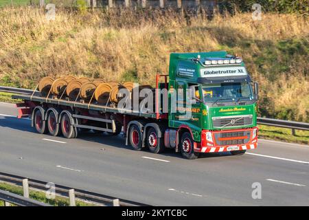 LAWSONS HAULAGE LTD; VOLVO Globetrotter XL lorry carrying rusty train wheels on flat back truck; travelling on the M6 Motorway, Manchester, UK Stock Photo