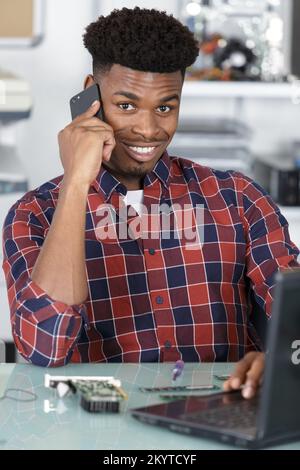 young handsome repairman repairing computer Stock Photo