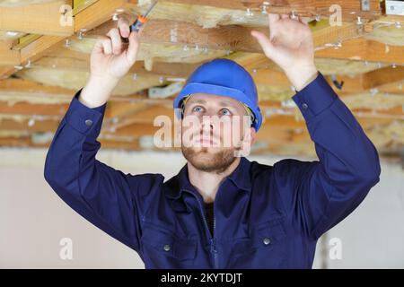 constructioncarpenter working on the roof of a wood house Stock Photo