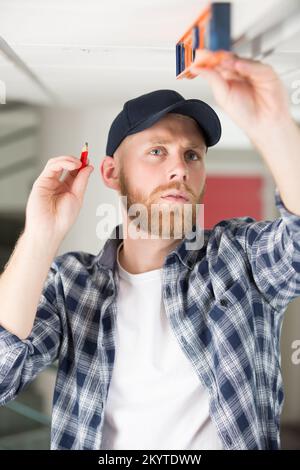 contractor taking ceiling measures with spirit level Stock Photo