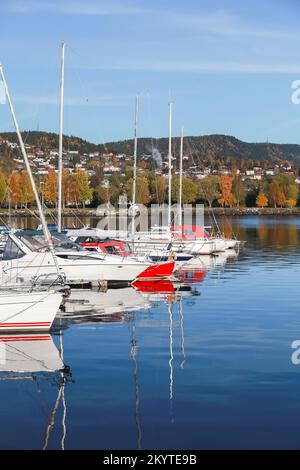 Norwegian coastal landscape with moored white red boats. Stenkjer, Trondheim region. Vertical photo Stock Photo