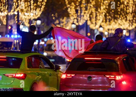 Paris, France, 01/12/2022. Moroccan and Tunisian supporters celebrate Morocco's qualification for the FIFA World Cup in Qatar, on the Champs Elysees, in Paris. Pierre Galan/Alamy Live News Stock Photo