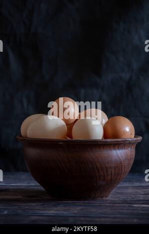 Chicken eggs in a clay plate on the table. Stock Photo