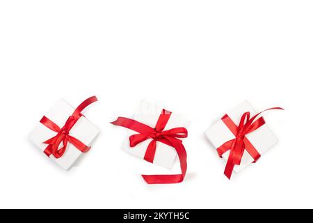 Three white boxes with red bows on a white background with copy space Stock Photo