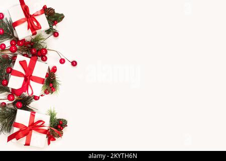Three white boxes with red bows and christmas ornaments on a white background with copy space Stock Photo