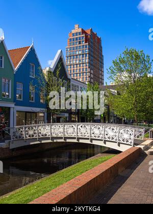 Zaandam, Netherlands - April 26, 2022: Pedestrian Bridge over the water channel and traditional architecture of buildings in Zaandam, Netherlands Stock Photo