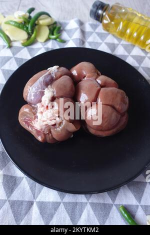 Raw fresh lamb kidneys on a chopping board  Stock Photo