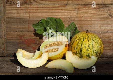 cut yellow melon on the vintage wooden background Stock Photo
