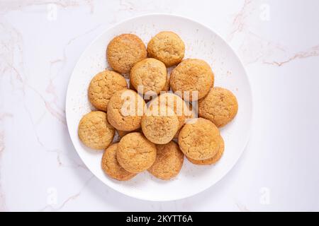 High angle view of homemade snickerdoodle cookies in a white plate on a marble surface with copy space Stock Photo