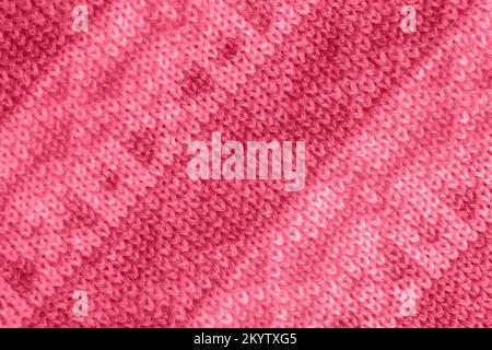 Trendy color of the year 2023. Knitted fabric with pattern, handmade. Background, texture toned in viva magenta color. Stock Photo