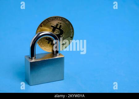 Bitcoin coin and lock blue background.Concept restrictions on financial transactions and trading Internet Stock Photo