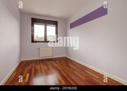 Empty room with reddish wooden flooring, smooth walls painted in light fuchsia and brown anodized aluminum window Stock Photo