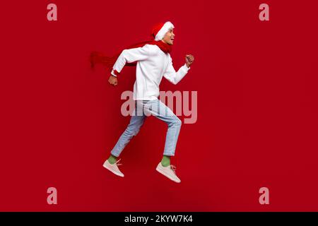 Full size profile portrait of energetic overjoyed guy run jump look empty space isolated on red color background Stock Photo