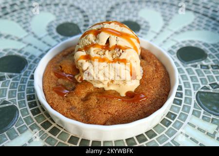 Delectable Warm Cookie Topped with Ice Cream and Salted Caramel Sauce Stock Photo
