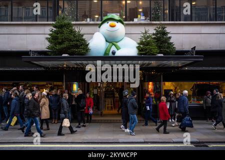 London, UK.  2 December 2022.  People pass Waterstones bookshop in Piccadilly whose exterior has been decorated for Christmas with The Snowman character from British author Raymond Briggs’ book.   Raymond Briggs died in August of this year aged 88.  Credit: Stephen Chung / Alamy Live News