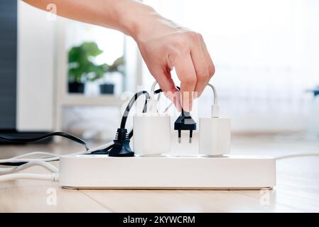 Plugging electrical plug on floor, socket at home. Energy efficiency concept Stock Photo